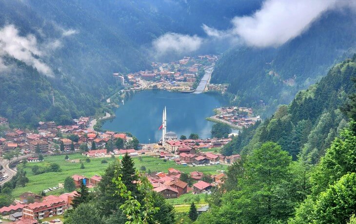 Uzungöl’ün seyir terasından görülen panoramik manzara: göl, cami minareleri, yaylalar ve sisli Karadeniz dağları.
